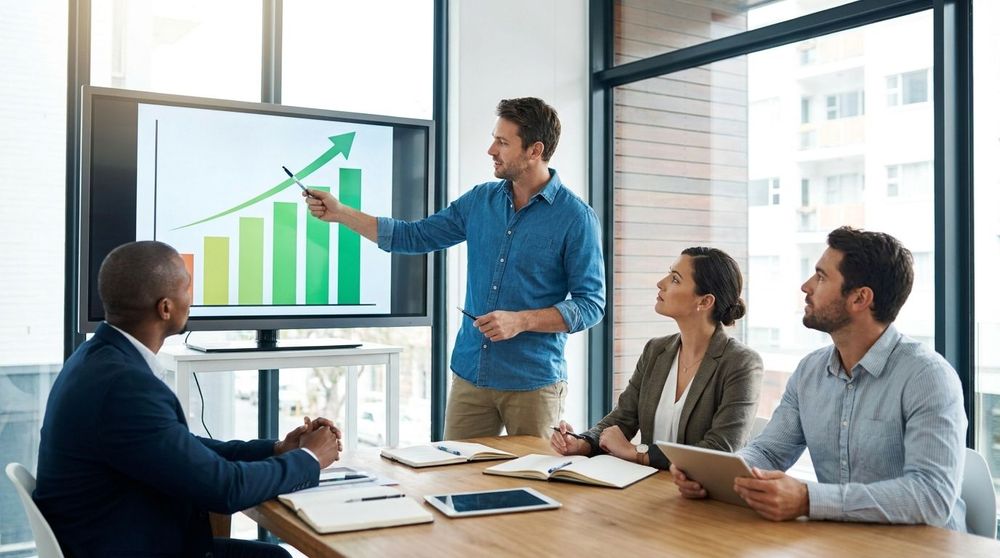 A close-up of a founder presenting a data-driven growth chart to a group of attentive investors in a modern office.